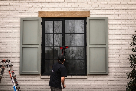 Professional window cleaning in Germantown, TN using a water-fed pole system to safely remove spring pollen and debris from a residential property.