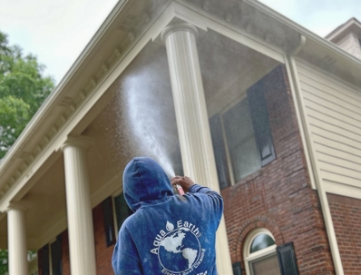 team power washing exterior of a home